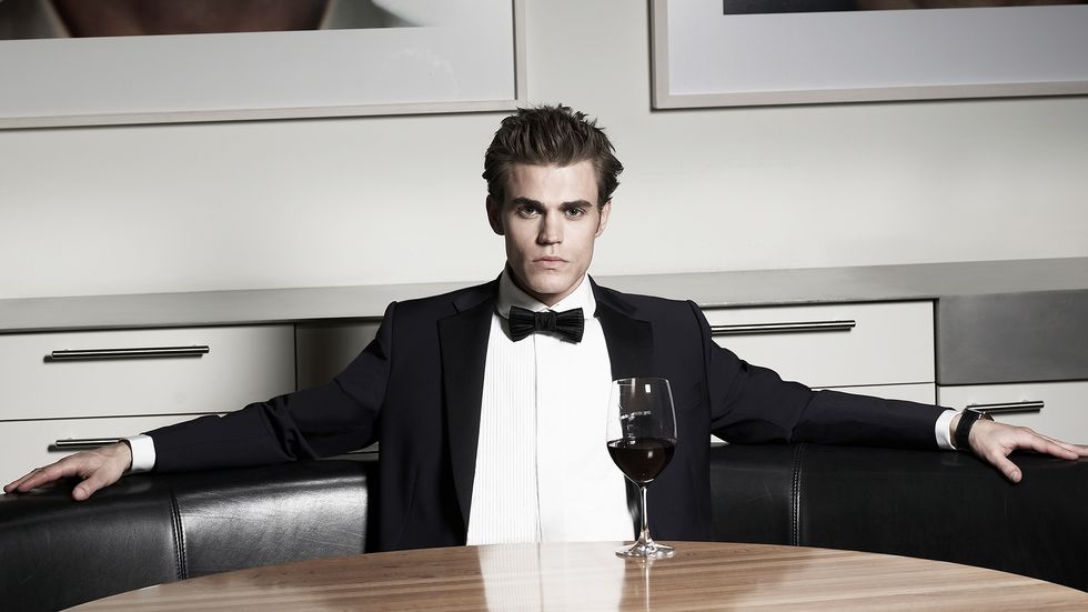Paul Wesley of Tell Me A Story wears a tuxedo and enjoys red wine
