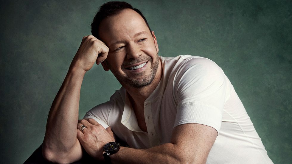 Donnie Wahlberg smiling in white shirt and black watch