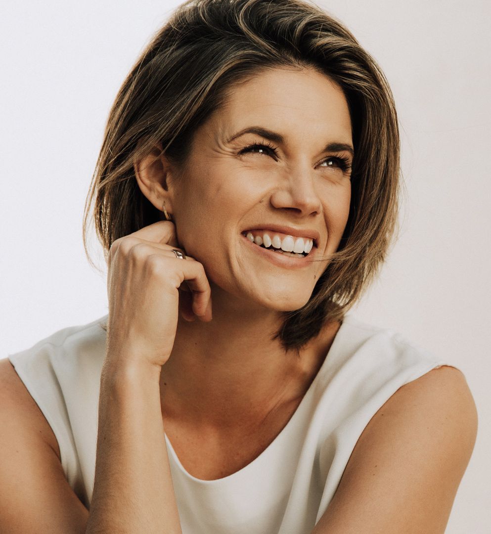 Missy Peregrym smiling in a sleeveless white top