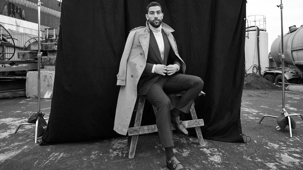 Zeeko Zaki in suit with black back drop