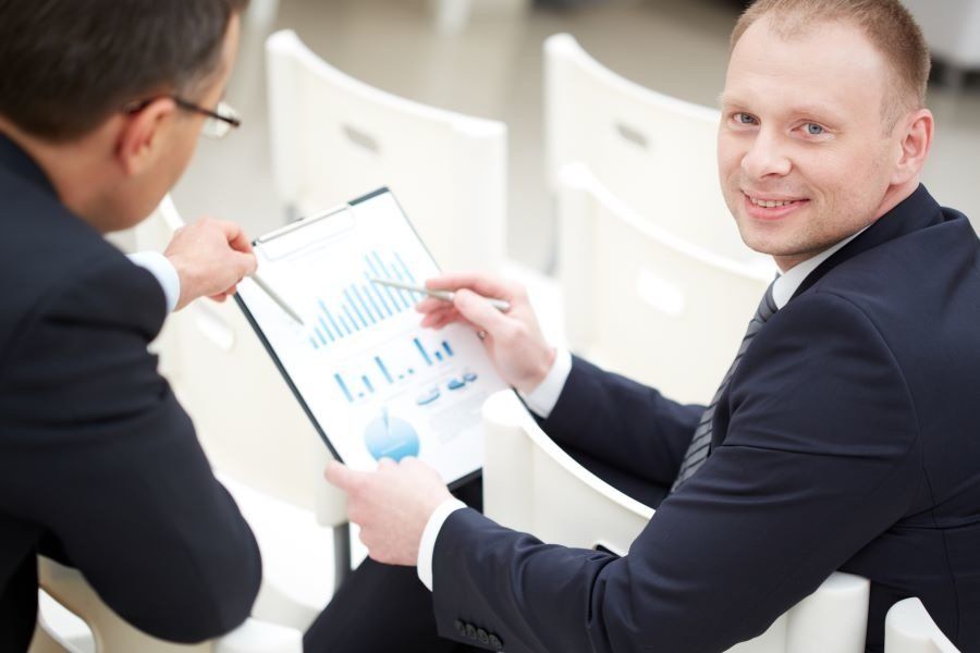 Statistician going over data with a business man in an office.