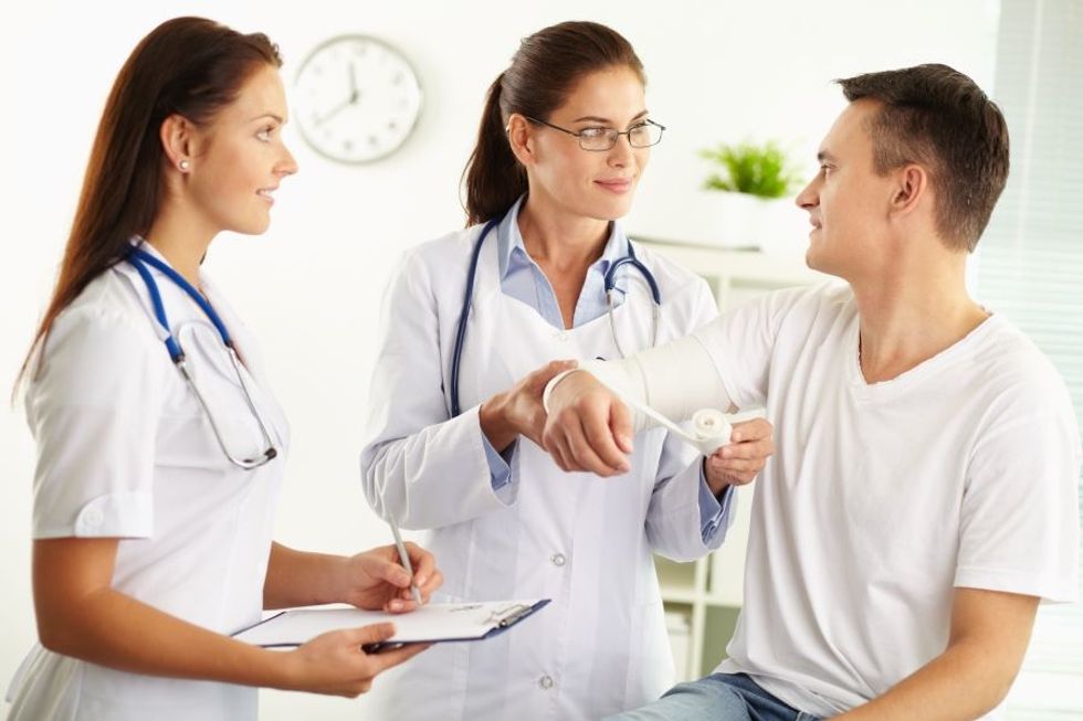 Physical therapist assistant helping examine a patient in a physical therapist's office.
