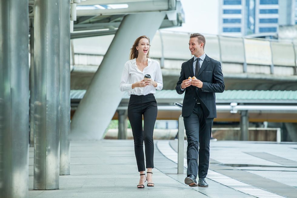 Businessman and businesswoman taking a break from work and walking outside in order to be more productive.