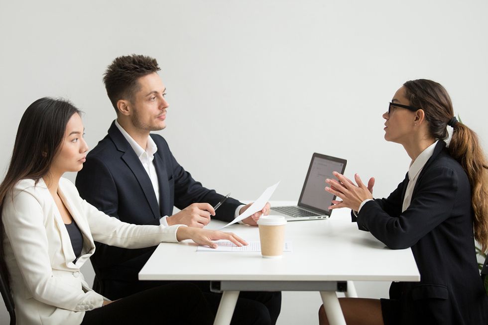 Male and female co-workers discussing how they can work better together in the office with their boss.