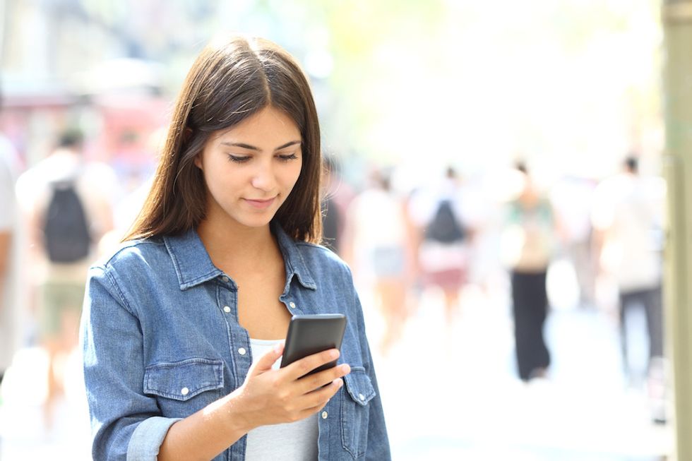 Teen using a smartphone in the street