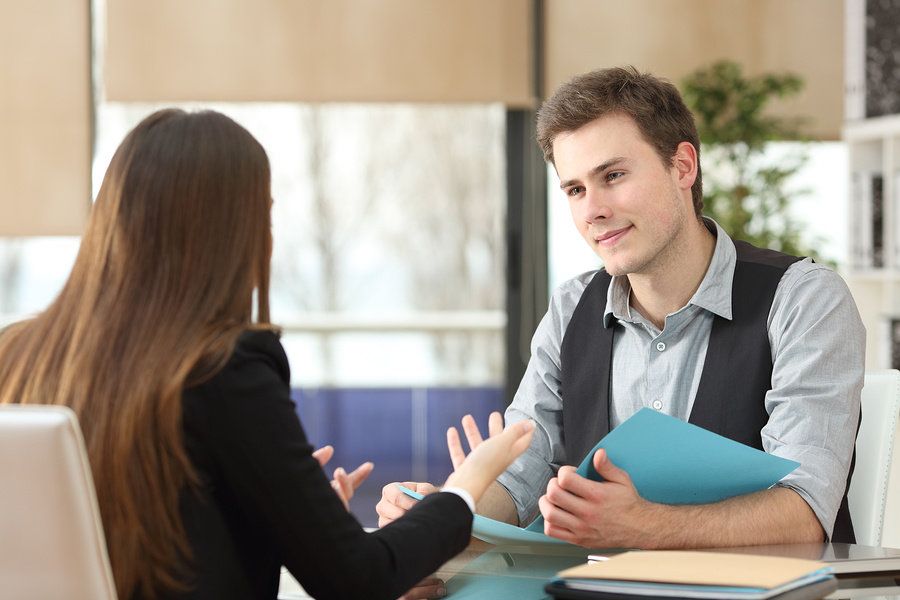 Young businessman listens as his supervisor gives a performance review.