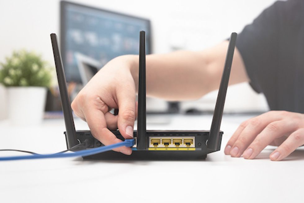 Hands connecting an internet cable to the router