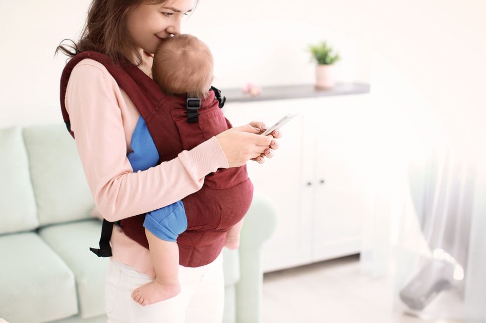 Working mom using her cell phone to look up apps that help her build good professional and personal habits.