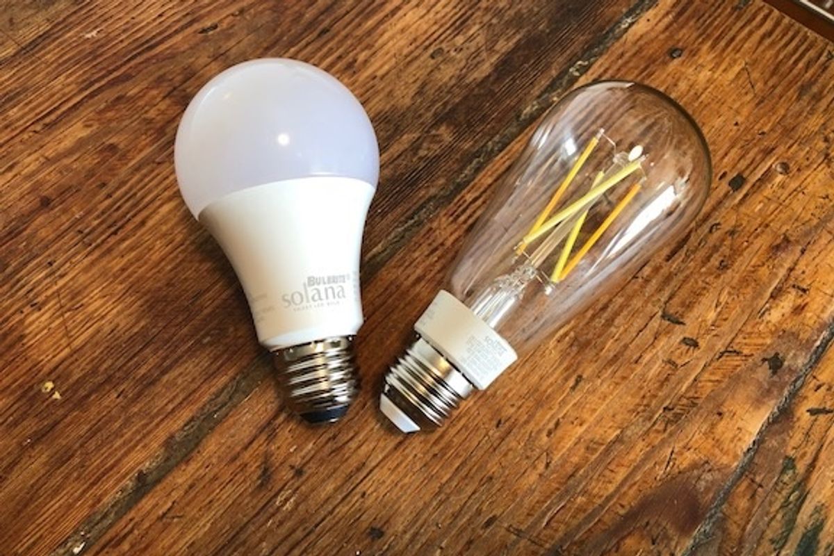 Two smart light bulbs, one standard and one with filament visible