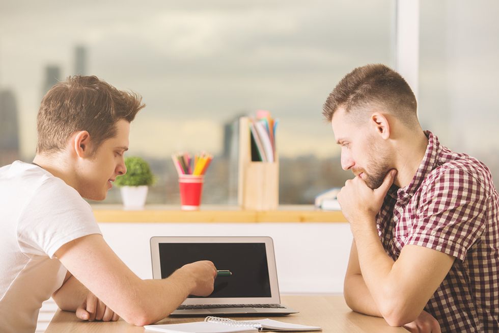 Young professional gets help from a friend during a mock interview.