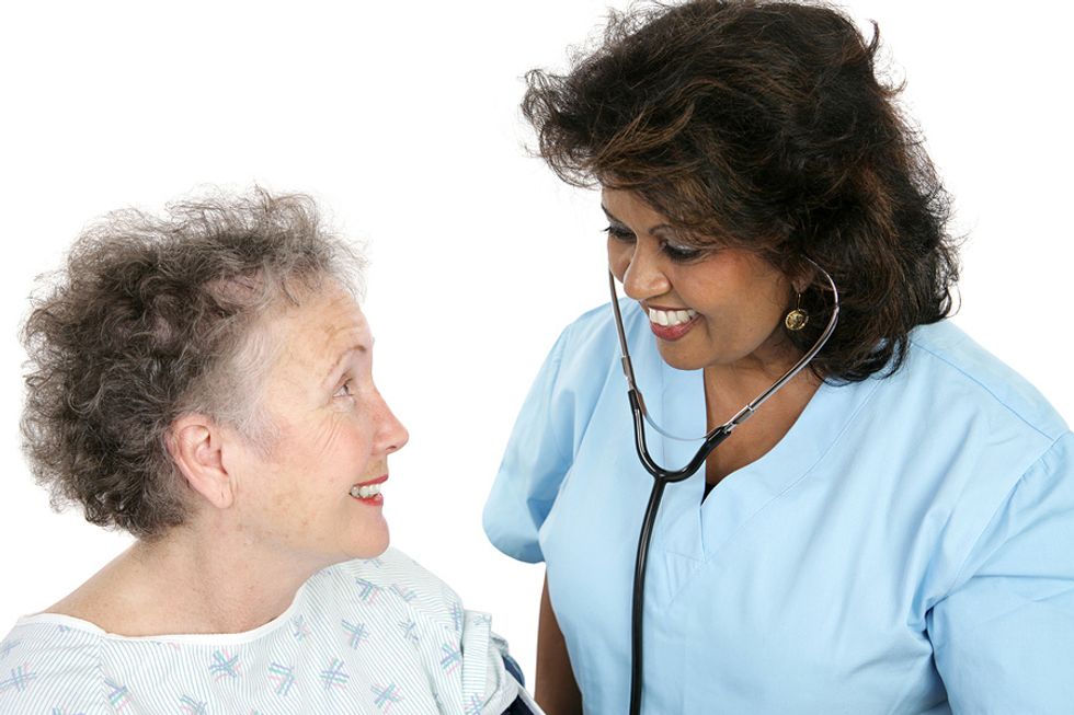 Female nurse practitioner checking up on an elderly female patient in a medical office.