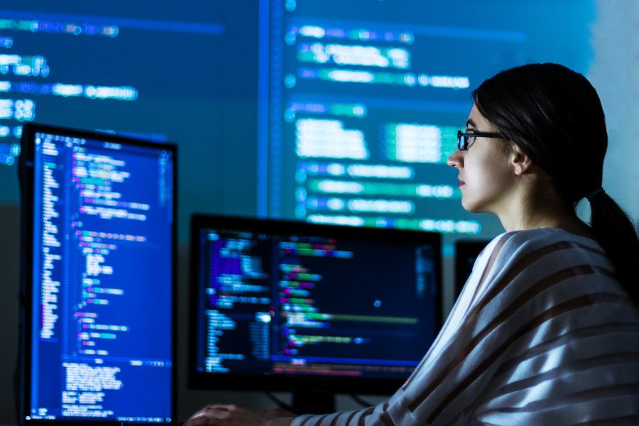 Female software developer coding a new software in her office.
