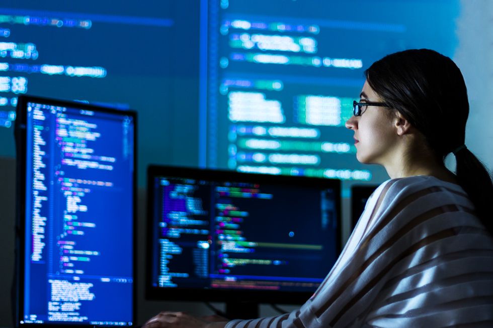 Female software developer coding a new software in her office.