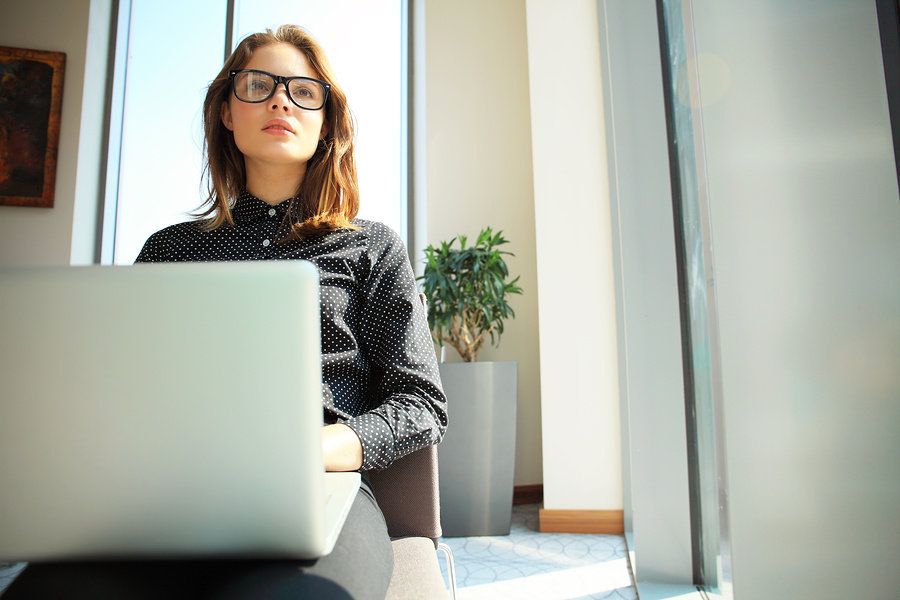 Female operations research analyst working on laptop in office and finding solutions to business issues.