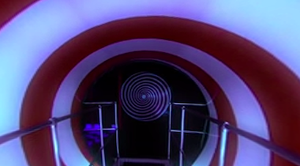 A red and white spiral surrounds a hallway with railing