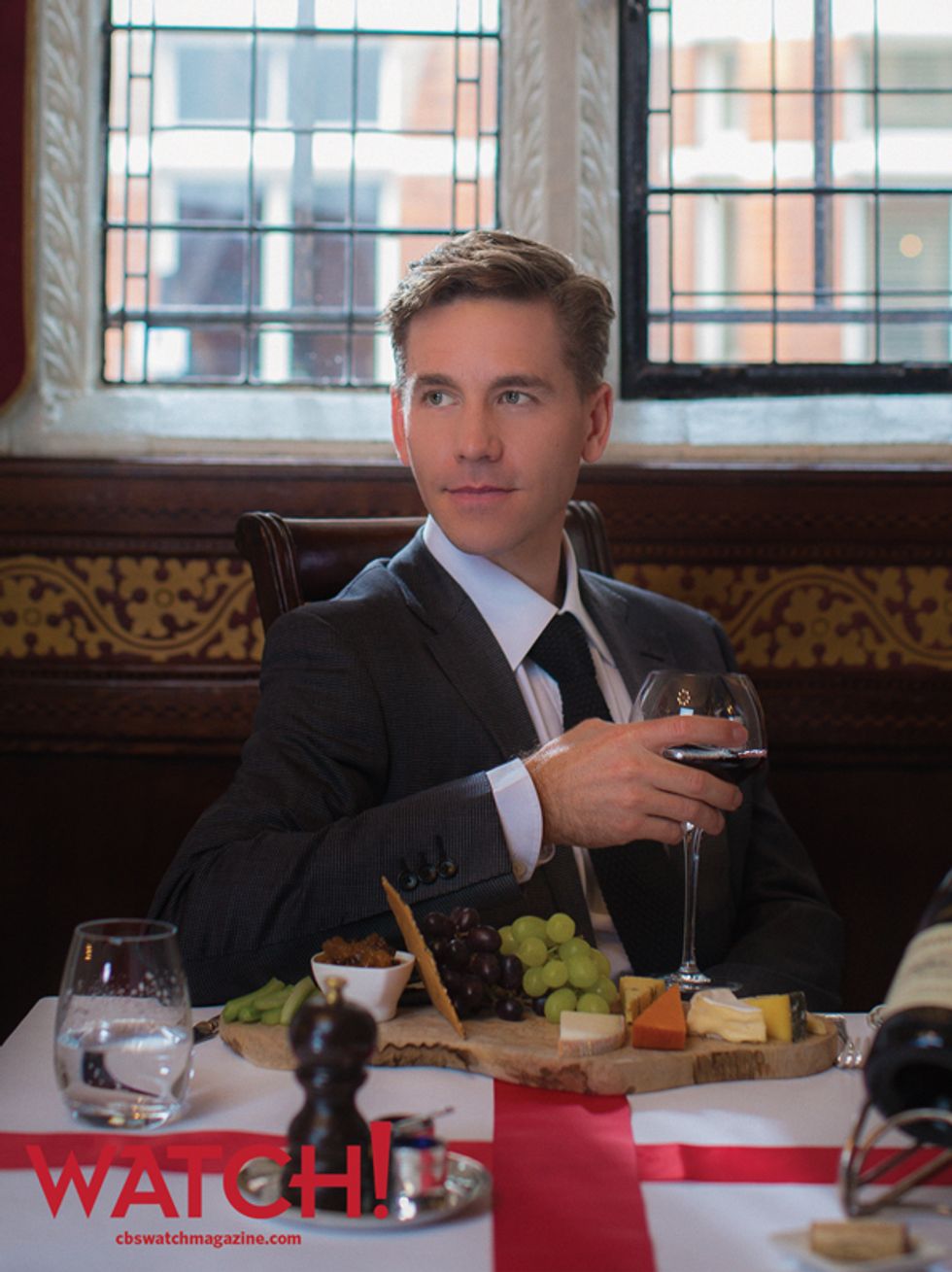 Brian Dietzen having a glass of red wine at a table with a charcuterie board