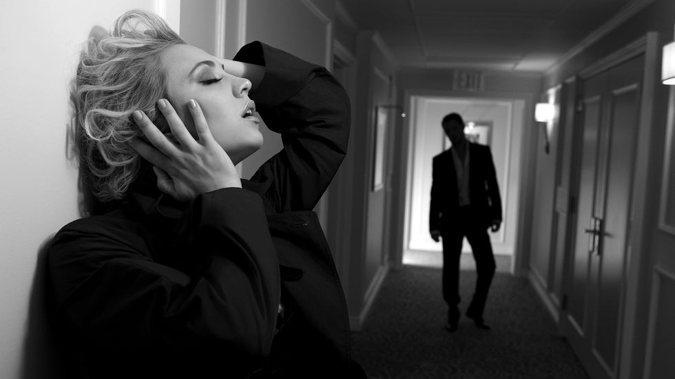 Kaley Cuoco in black suit, hallway