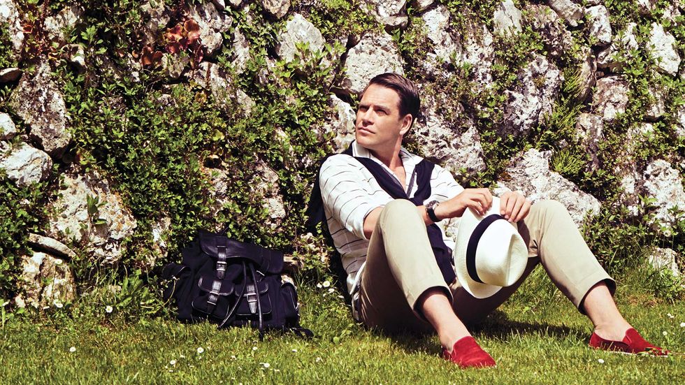Michael Weatherly of Bull with red shoes sitting on grass