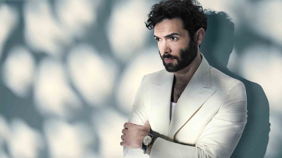 Ethan Peck of Star Trek Discovery in a white jacket and tank top