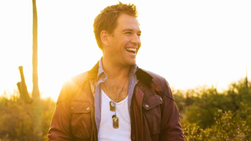 Michael Weatherly of Bull in brown bomber jacket and dog tags