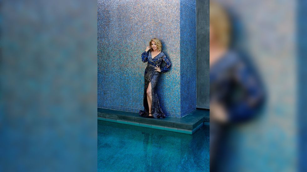 Melody Thomas Scott of The Young and the Restless in a blue beaded gown against a blue tiled wall