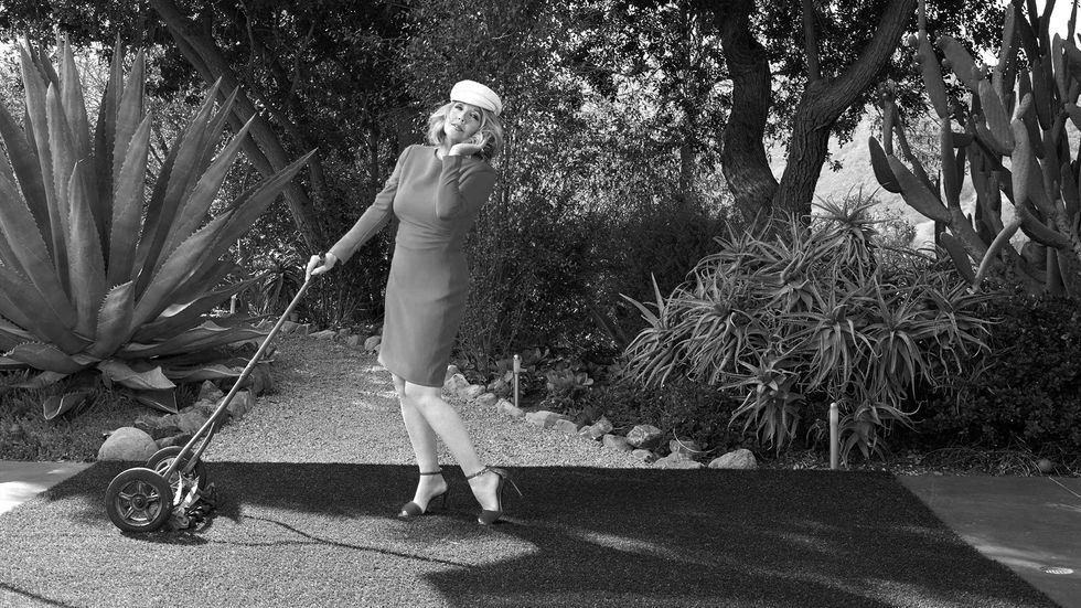 Melody Thomas Scott of The Young and the Restless pretending to use an old fashioned lawn mower