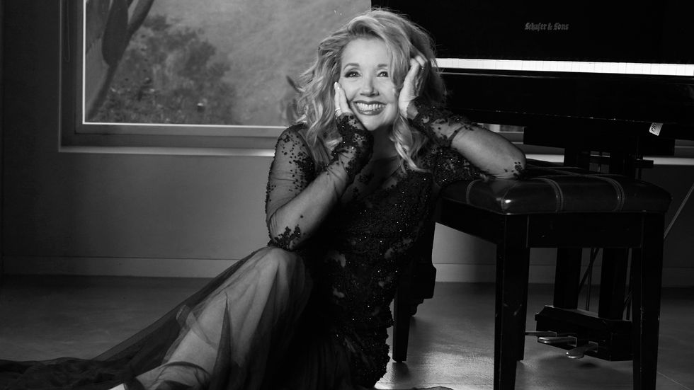 Melody Thomas Scott of The Young and the Restless leaning on a piano bench