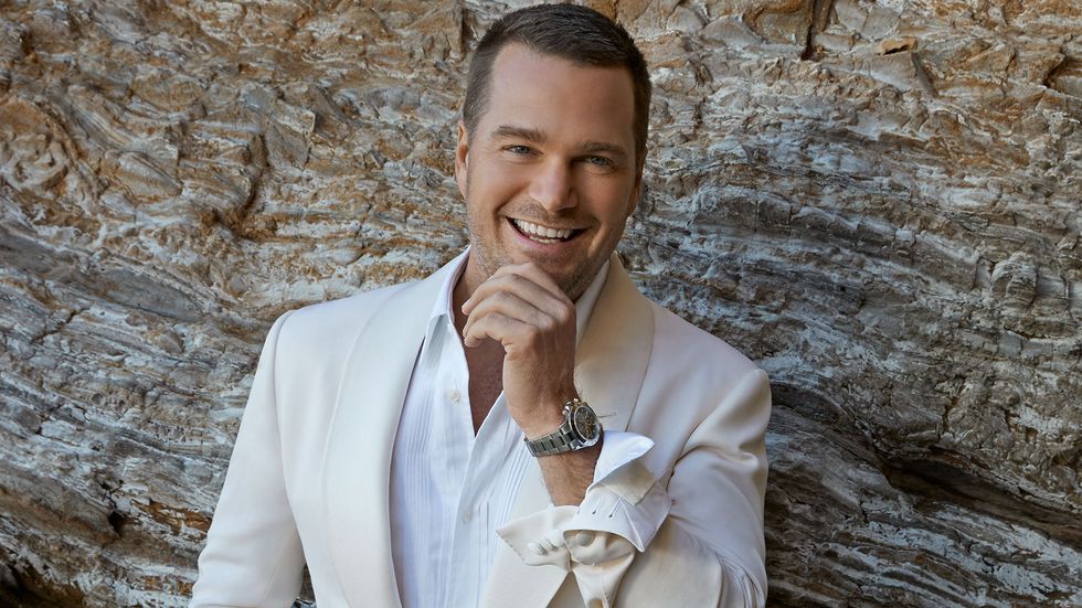 Chris O Donnell of NCIS Los Angeles in white suit up against rocks