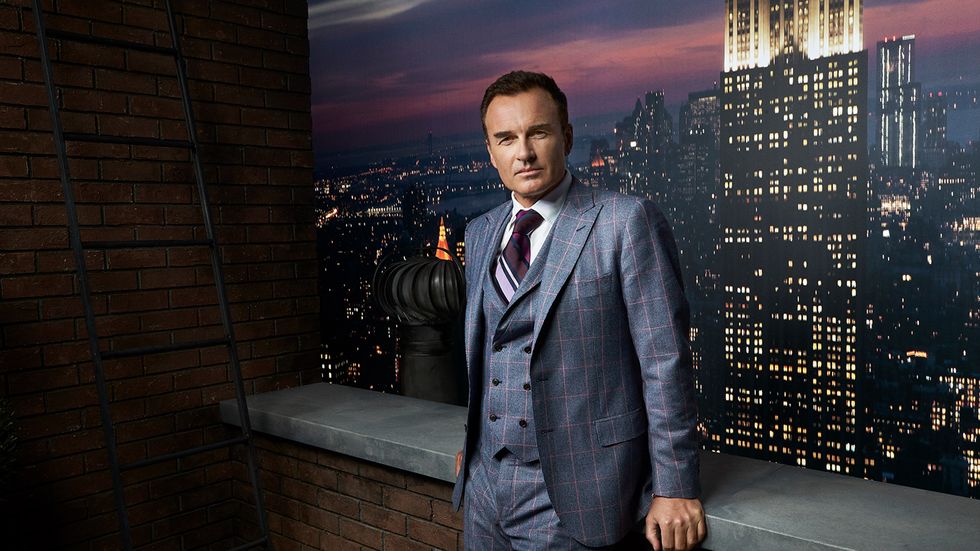 Julian McMahon in checkered suit in front of Empire State Building