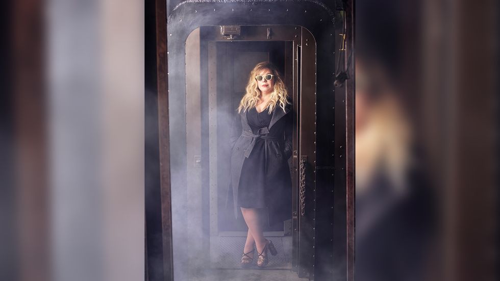 Kristen Vangsness in a black dress and black trench coat