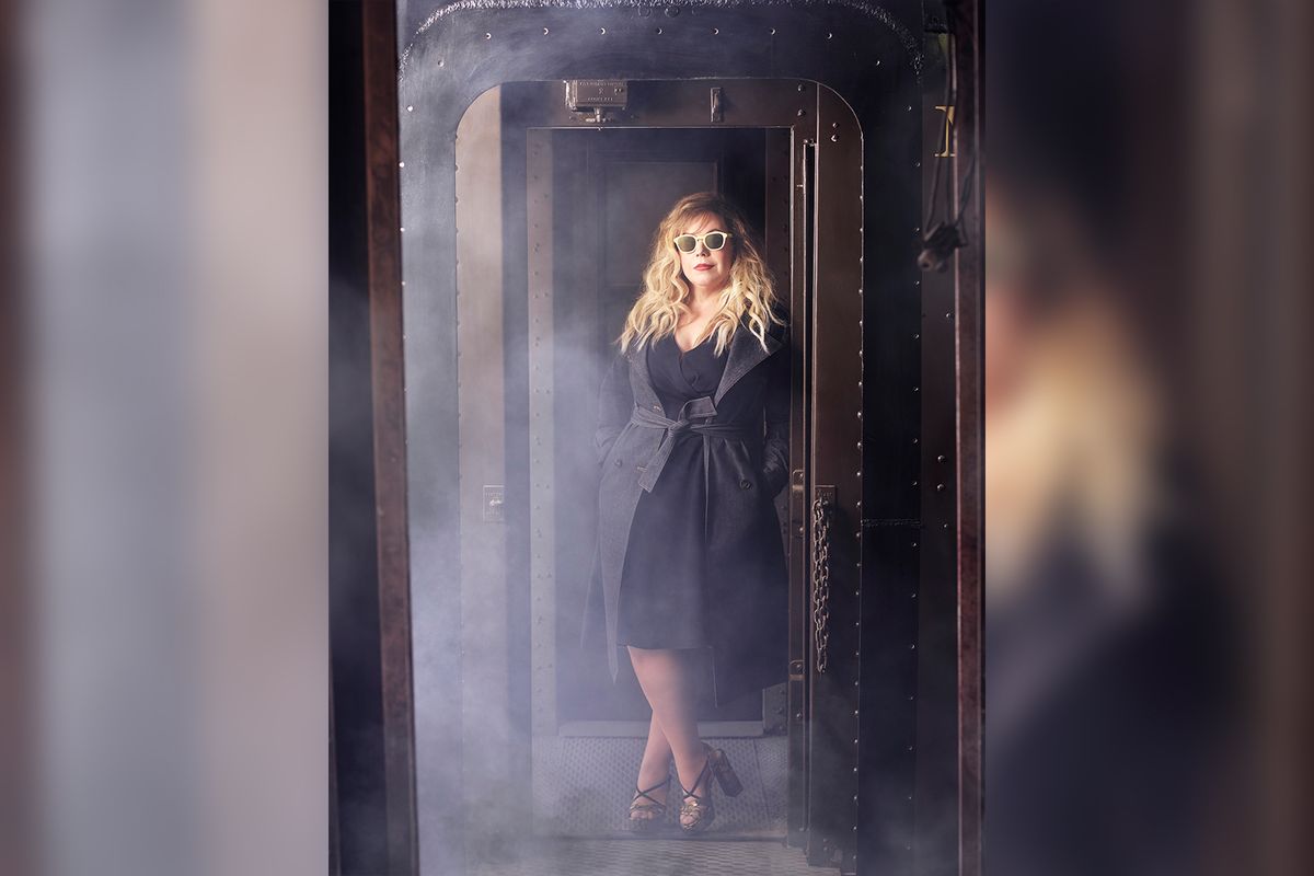 Kirsten Vangsness in a black dress and black trench coat