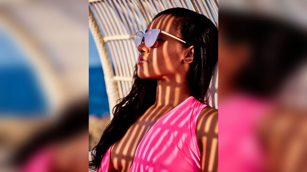 Candice Patton wearing hot pink bathing suit wearing sunglasses