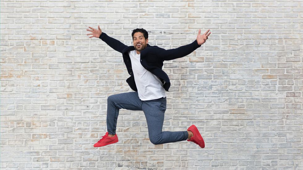 Adam Rodriguez of Criminal Minds jumping in front of a brick wall