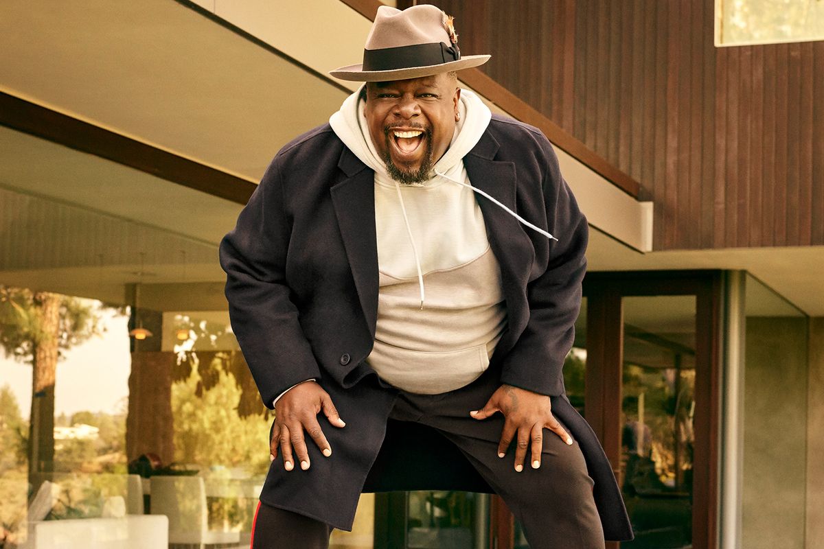 Cedric the Entertainer of The Neighborhood in hoodie and overcoat