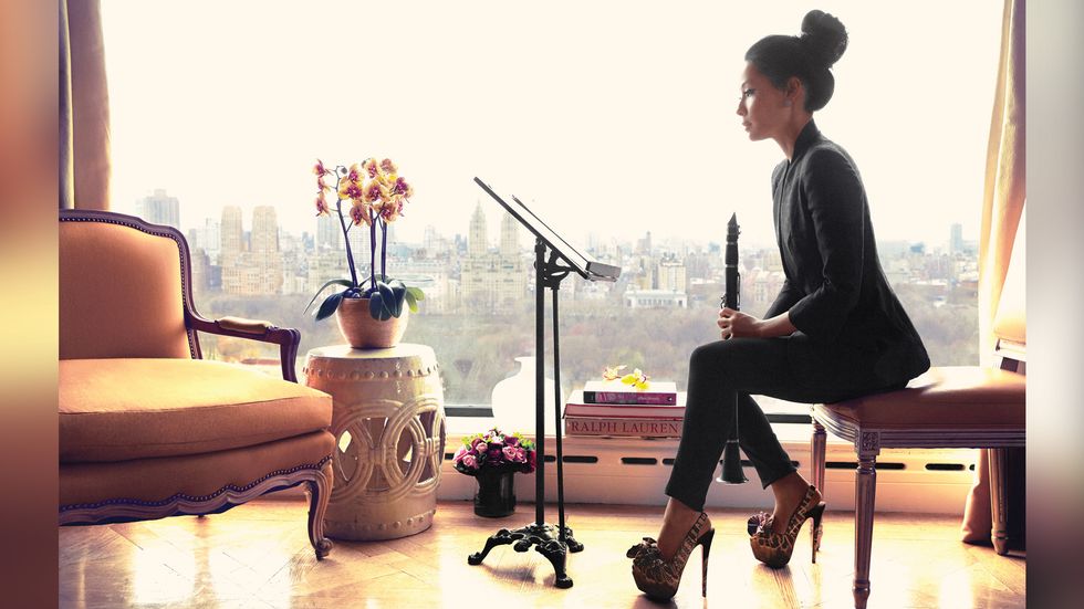 Lucy Liu playing the clarinet over looking NYC