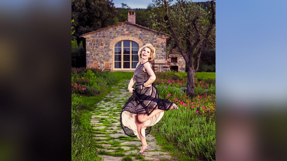 Christine Baranksi jumping in black and cream dress