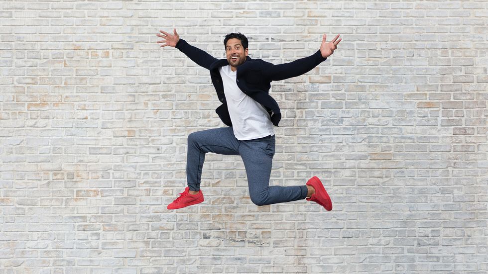 Adam Rodriguez jumping with red sneakers