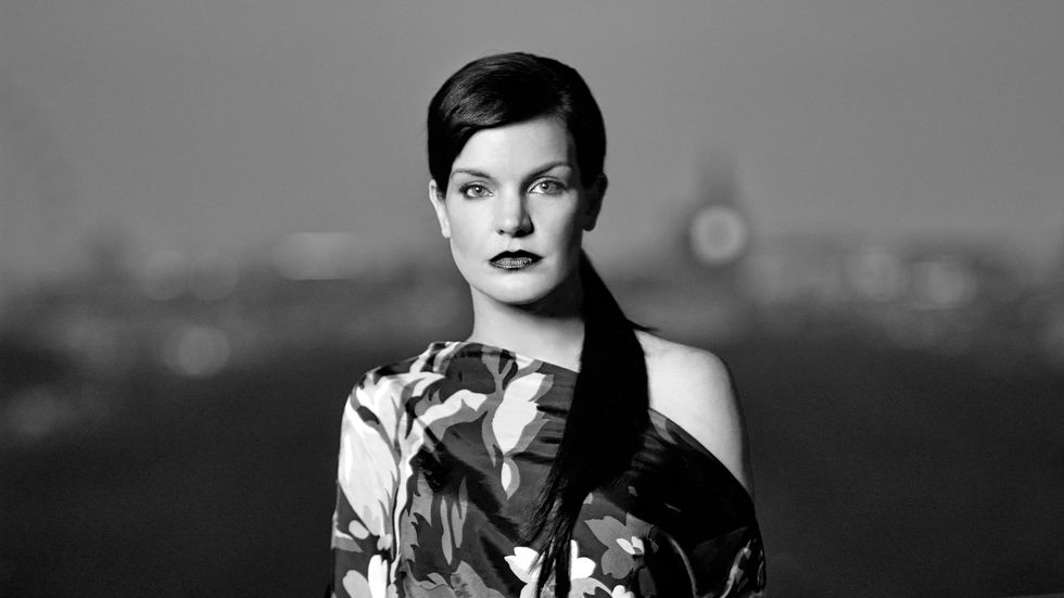 Black and white image of Actress Pauley Perrete in a floral print dress.