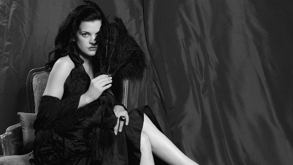Black and white image of Actress Pauley Perrete in a dramatic black dress.