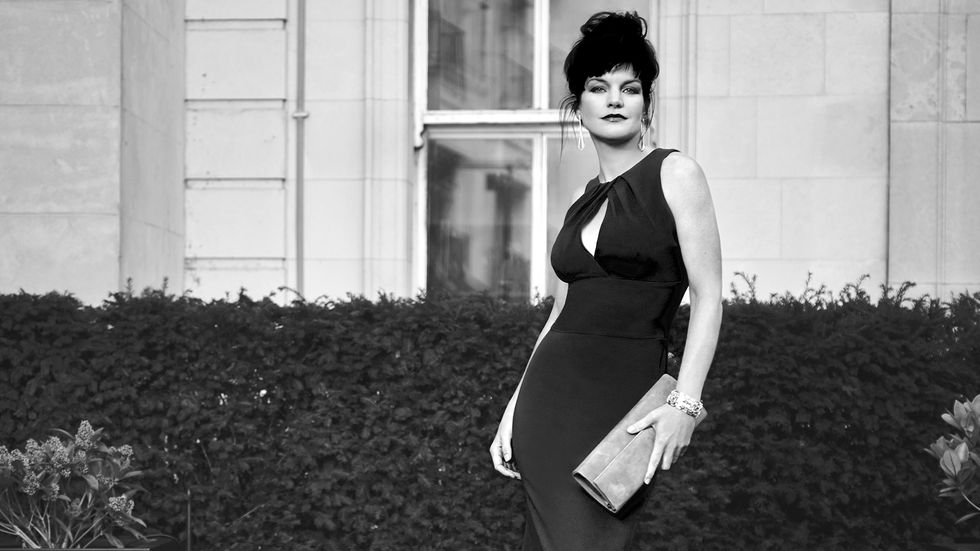 Black and white image of Actress Pauley Perrete in a form-fitting black dress.