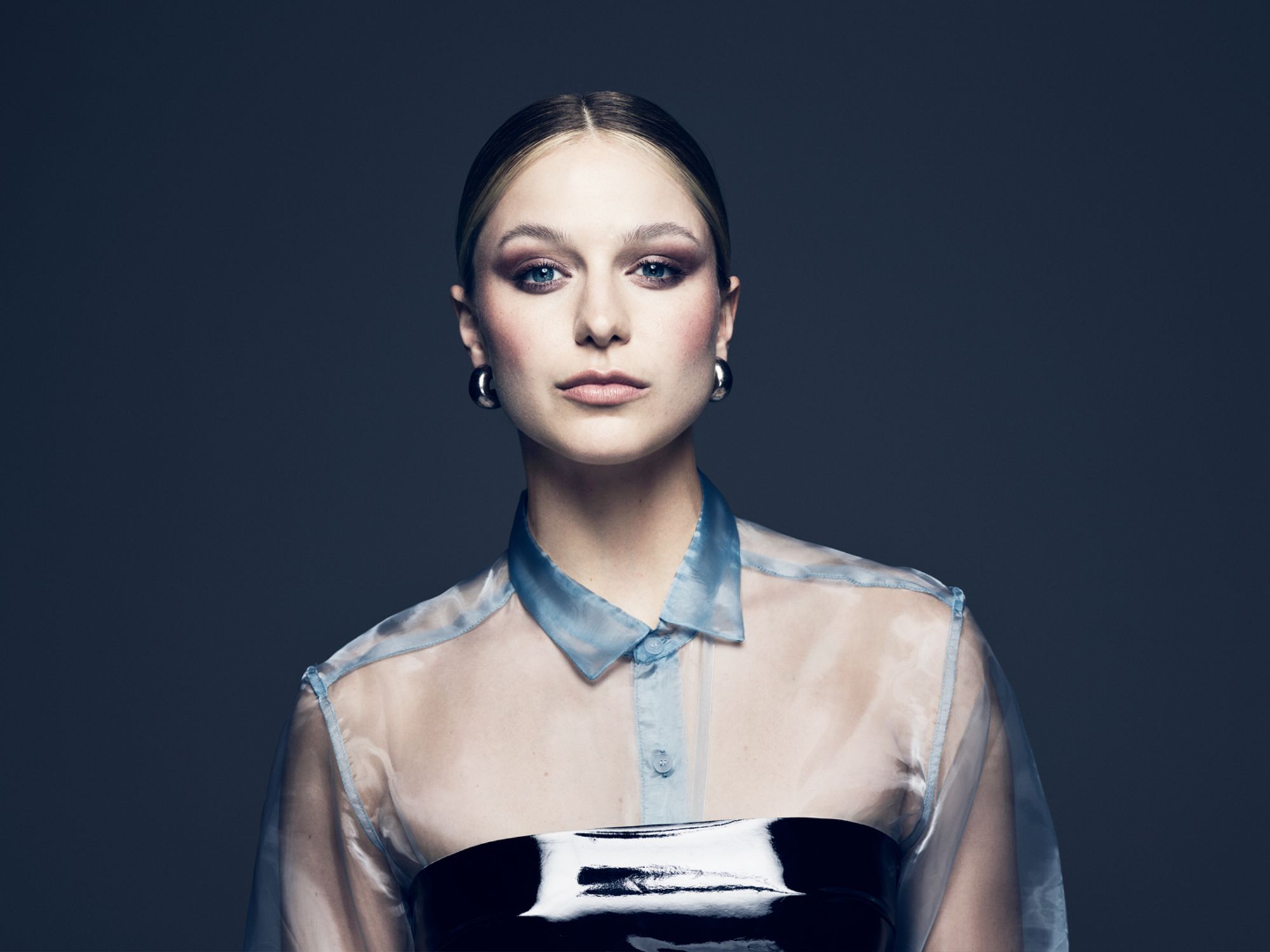 Melissa Benoist wears a sheer transluscent blue top.