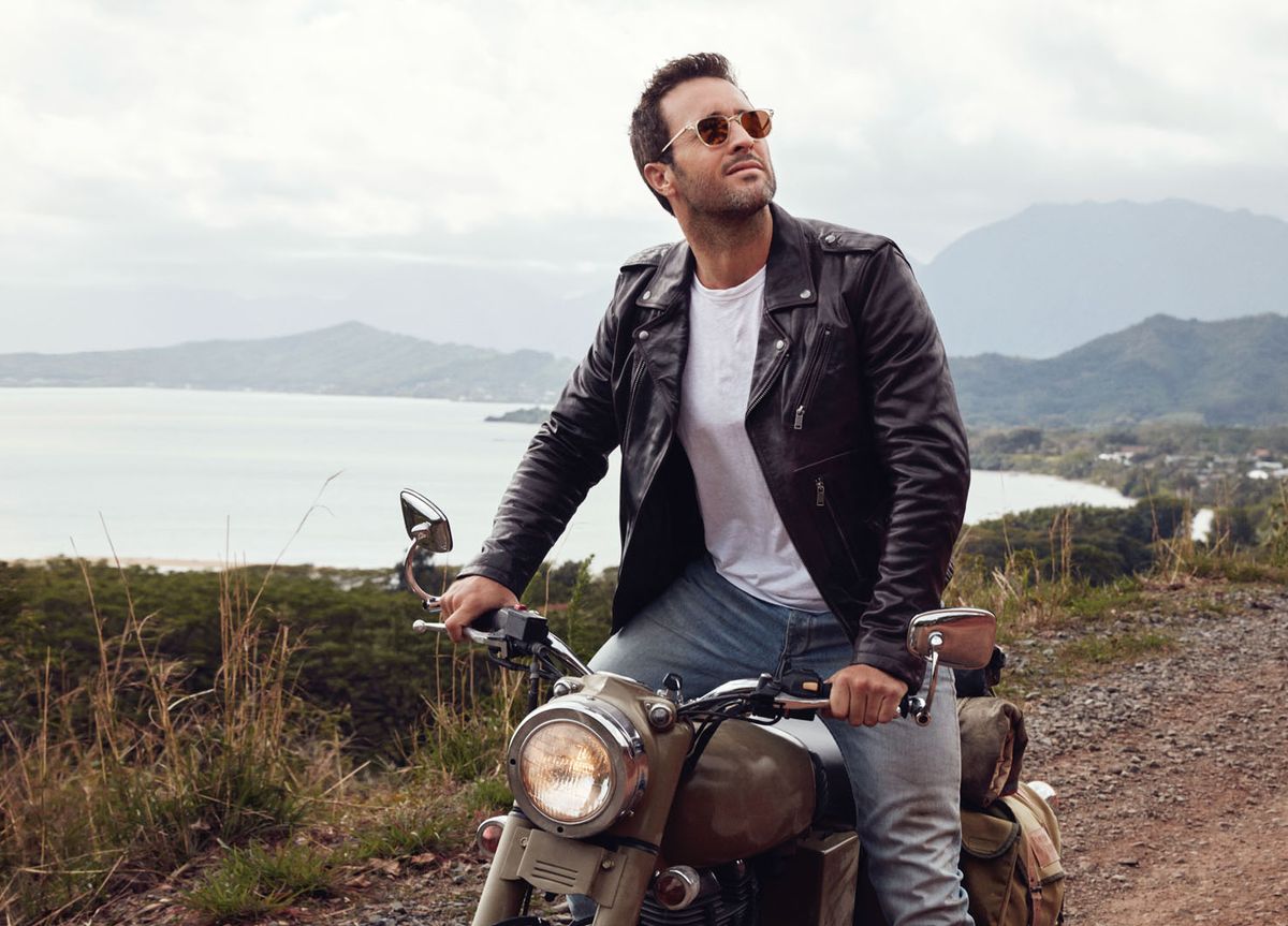 Alex OLoughlin of Hawaii Five 0 in a black leather jacket on a motorcycle