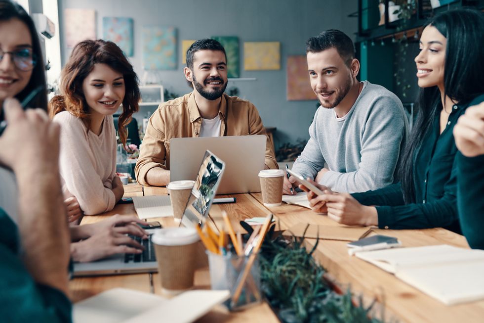 Group of young professionals building relationships with one another and gaining confidence during work.