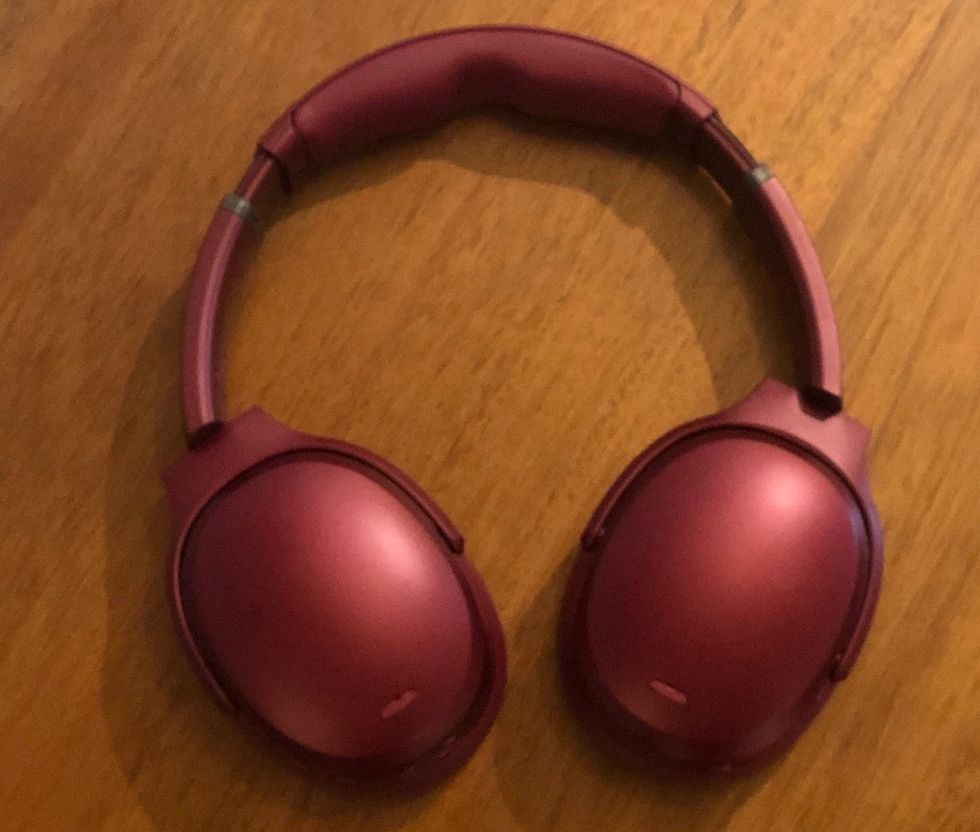 A pair of red Crusher ANC headphones from Skullcandy on a wood table