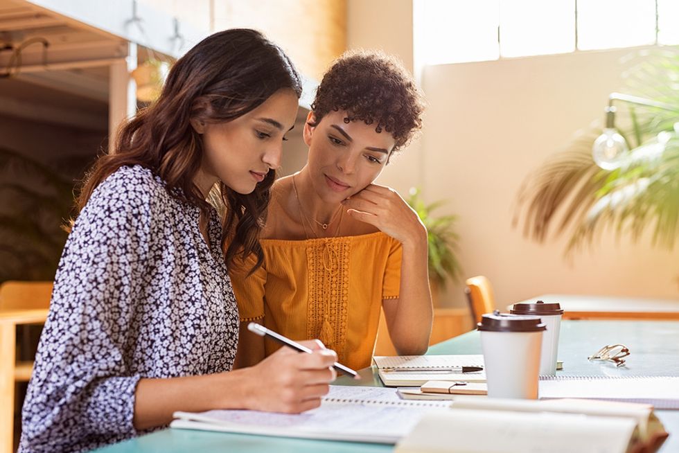 Young professional does a mock interview with her friend.