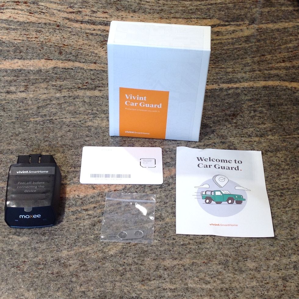 Photo of Vivint Car Guard box and the contents inside.