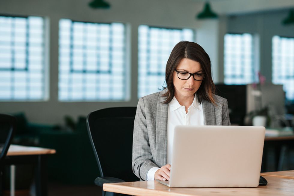 Business woman sitting at her desk and focusing on her most important tasks at work.