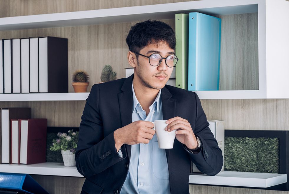 Young professional man drinking coffee and taking a break from work.