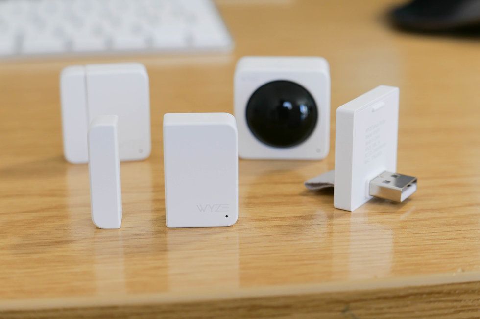 A small white camera and white plastic sensors on the top of a wooden desk