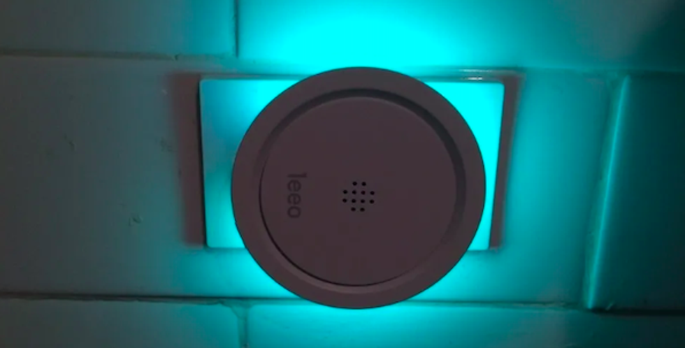 Leeo Smart Alert plugged in and glowing a blue-green